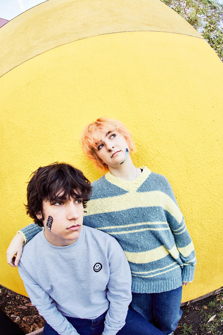Two teens hanging out, one wearing a World of Hurt fabric bandage on the cheek